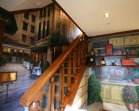 A staircase with a mural on the wall and a sign that says ellis