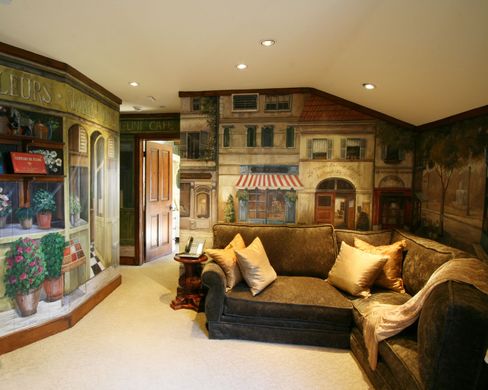 A living room with a couch and a mural on the wall