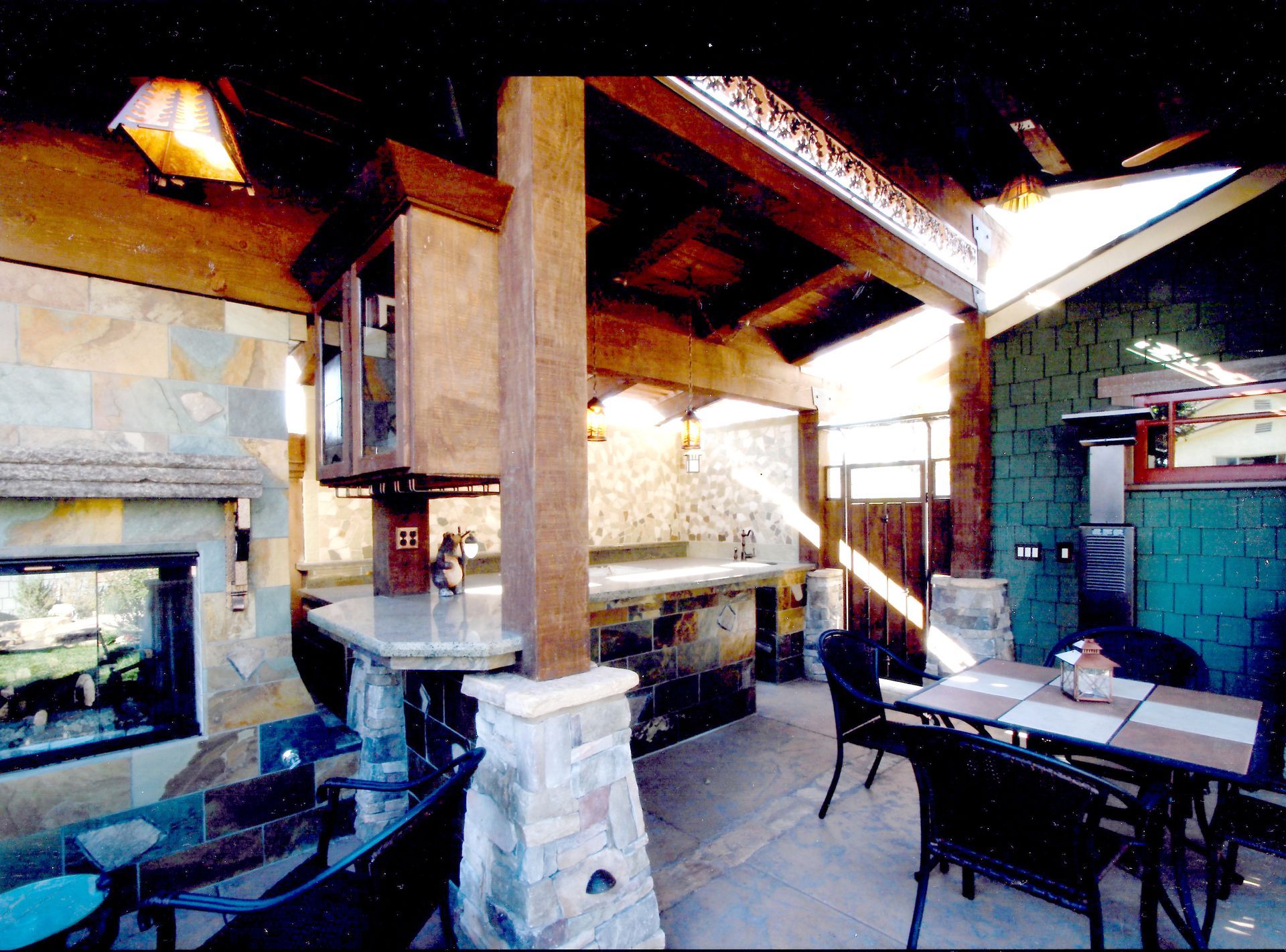 A patio with a table and chairs and a fireplace