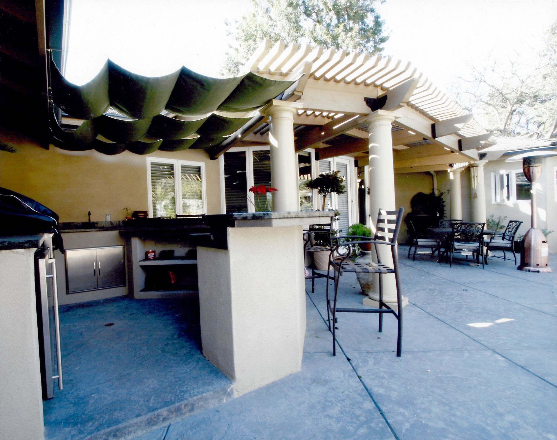 A patio area with a striped awning over it