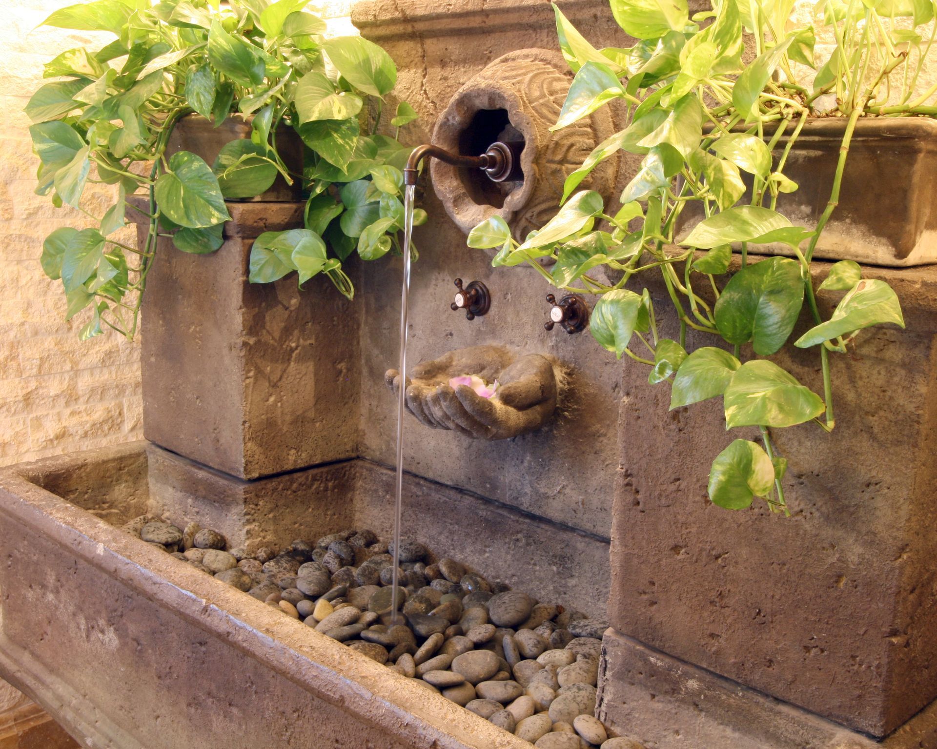 A water fountain with plants and rocks in it