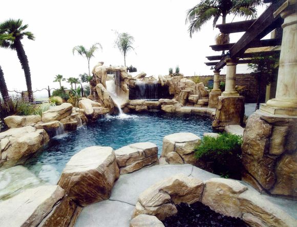 A swimming pool with a waterfall in the background