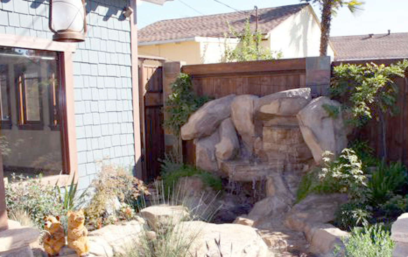 A waterfall is in the backyard of a house