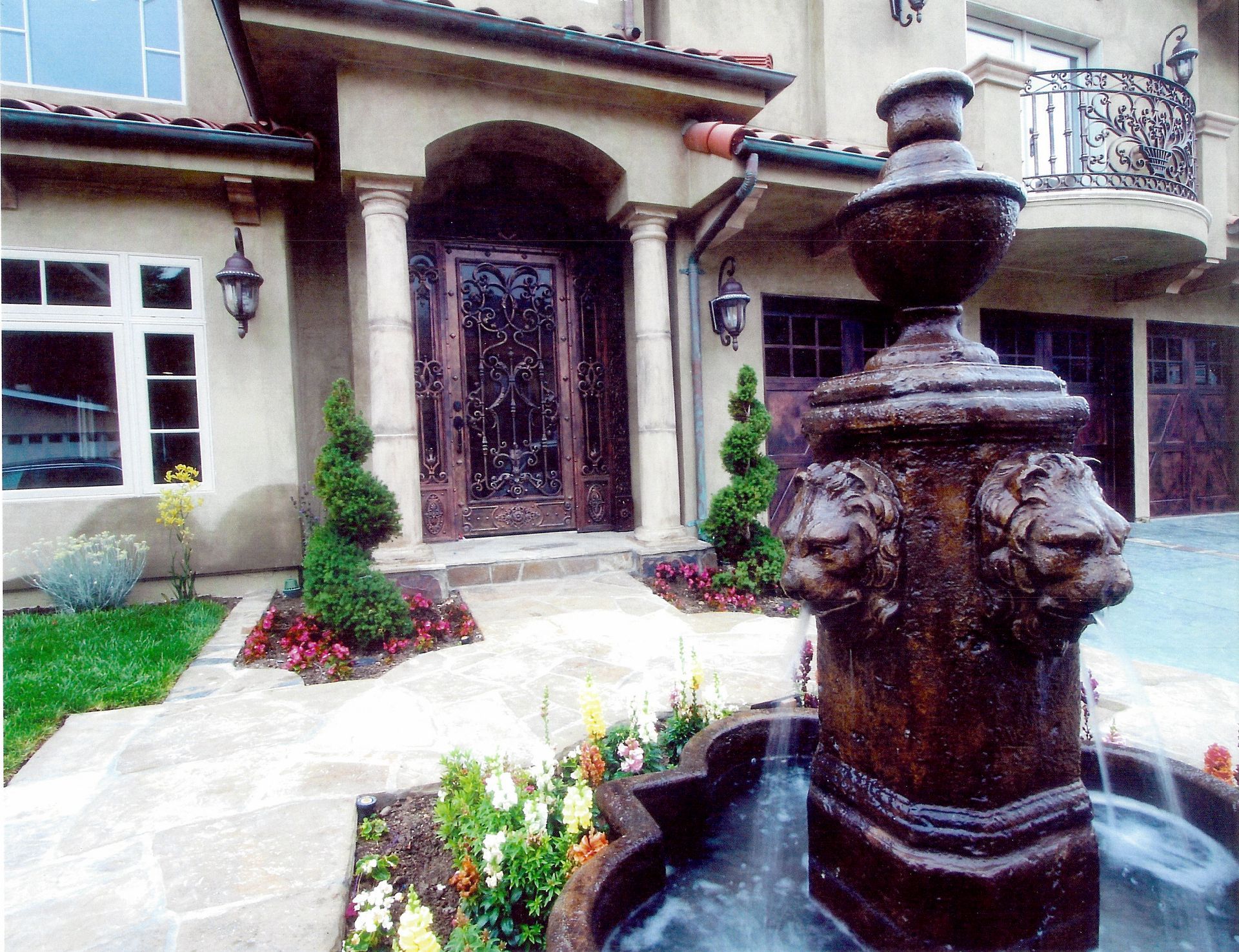 A large house with a fountain in front of it