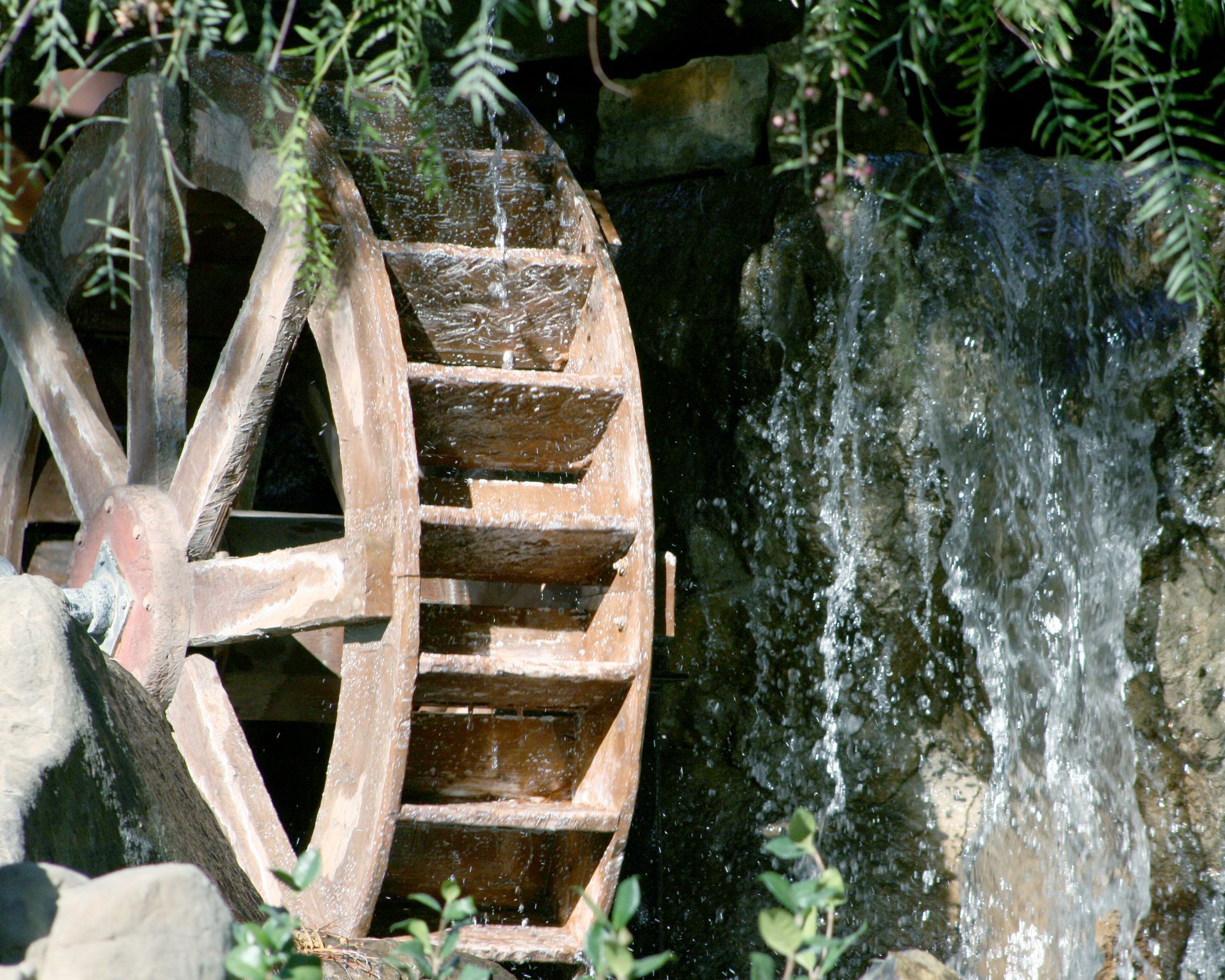 A water wheel is in front of a waterfall