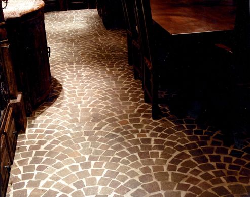 A dark room with a brick floor and a wooden table