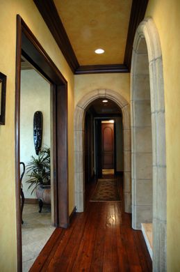 A long hallway with arches and wooden floors