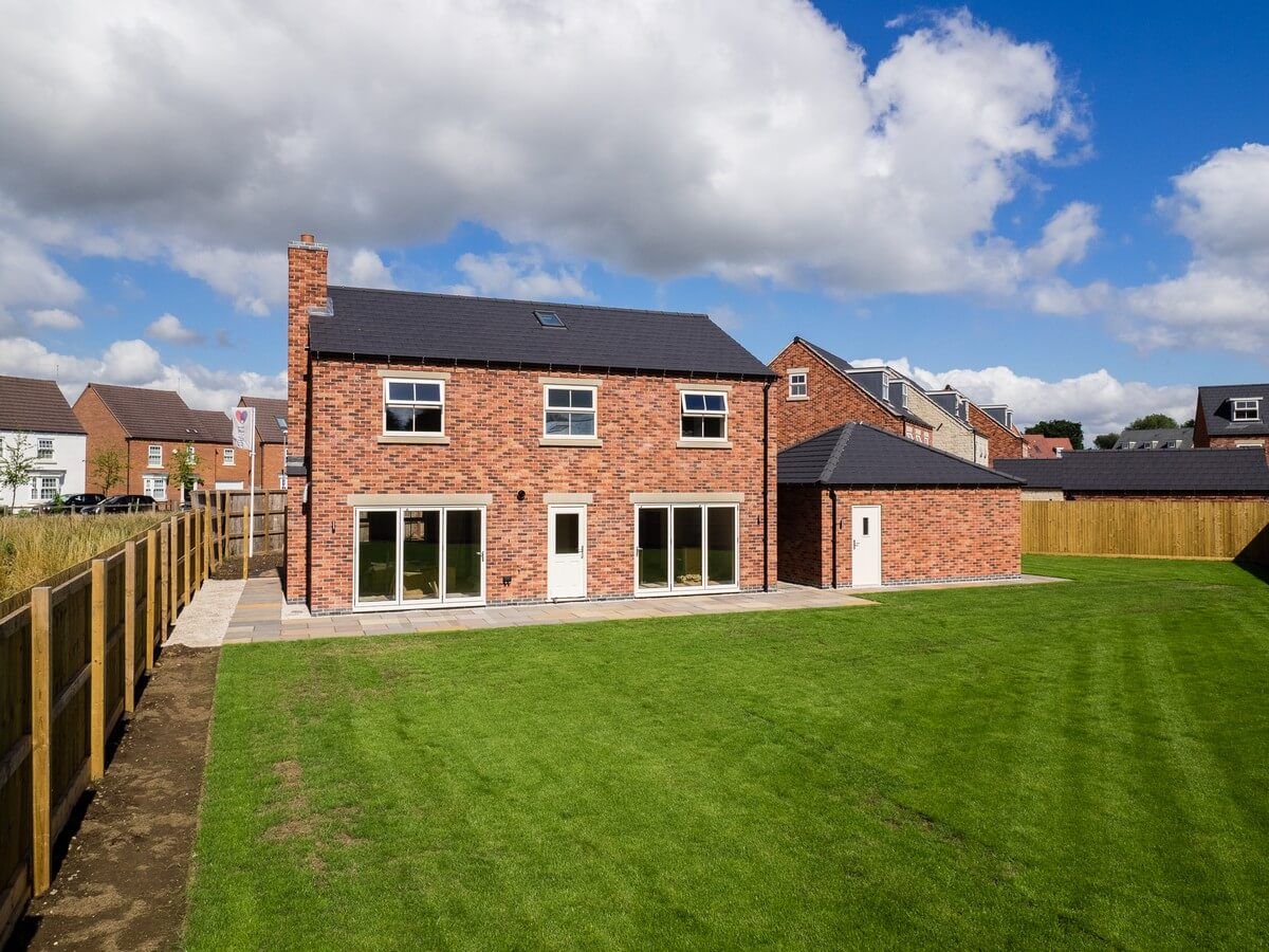 side view of house and green grass back yard