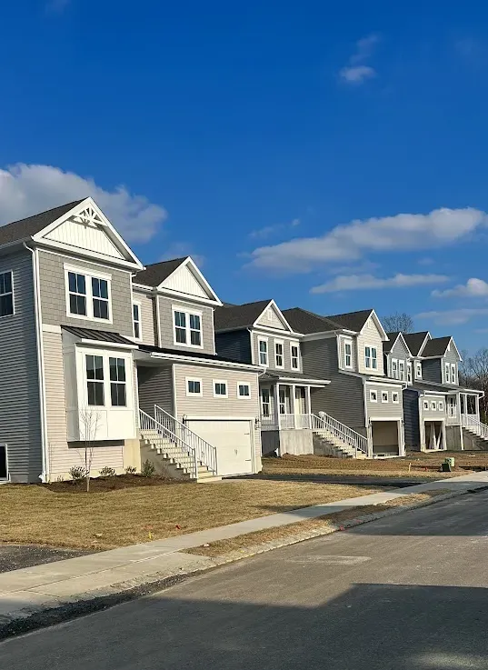 Maple Glen PA exterior painting – row of freshly painted houses under blue sky by Oasis Painting & Drywall