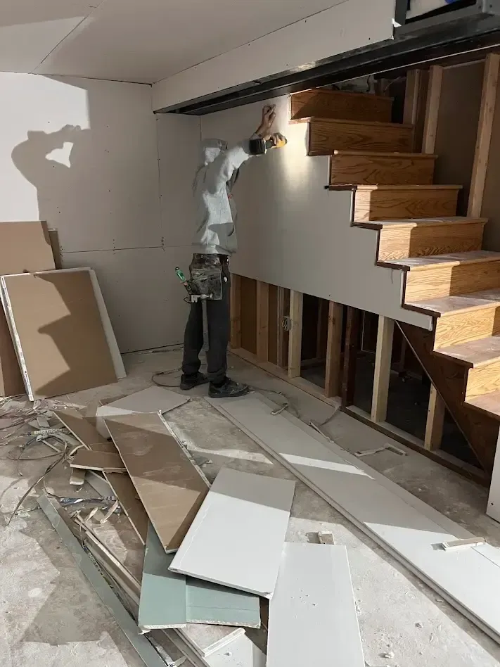 Professional drywall installation on stairs during a home renovation in Drexel Hill, PA.
