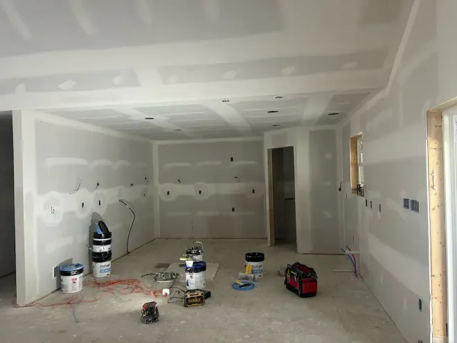 Wayne PA drywall installation – interior room with walls and ceiling finished tools on floor by Oasis Painting & Drywall.