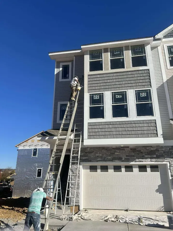 Reading PA exterior painting – professional painter on ladder working on house side by Oasis Painting & Drywall.