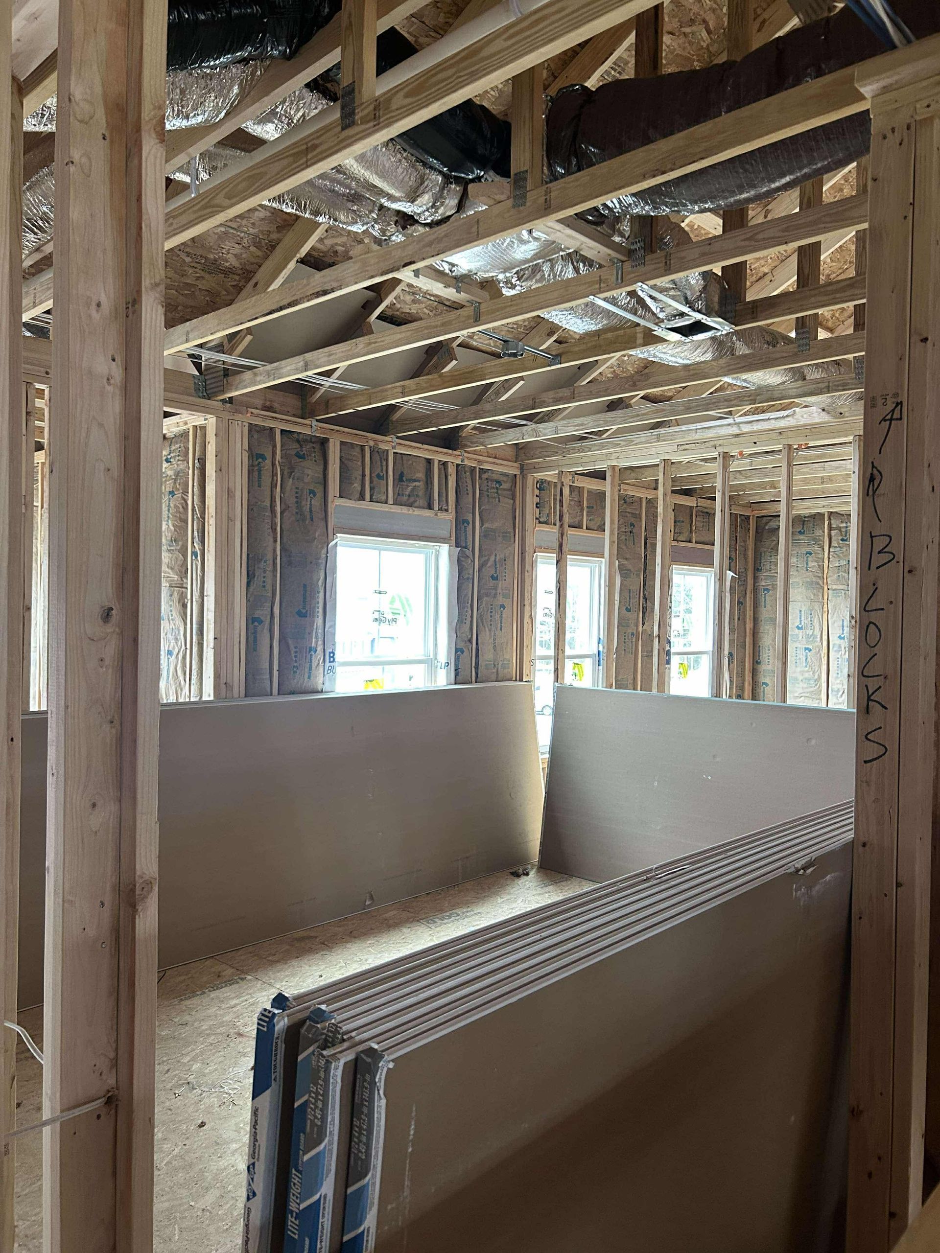 A room in a house under construction with a lot of wooden beams.