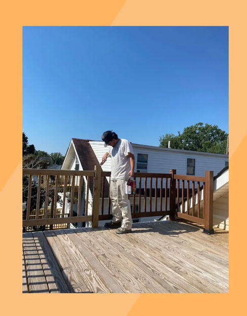 Philadelphia PA exterior painting – man painting wooden deck railing by Oasis Painting & Drywall.