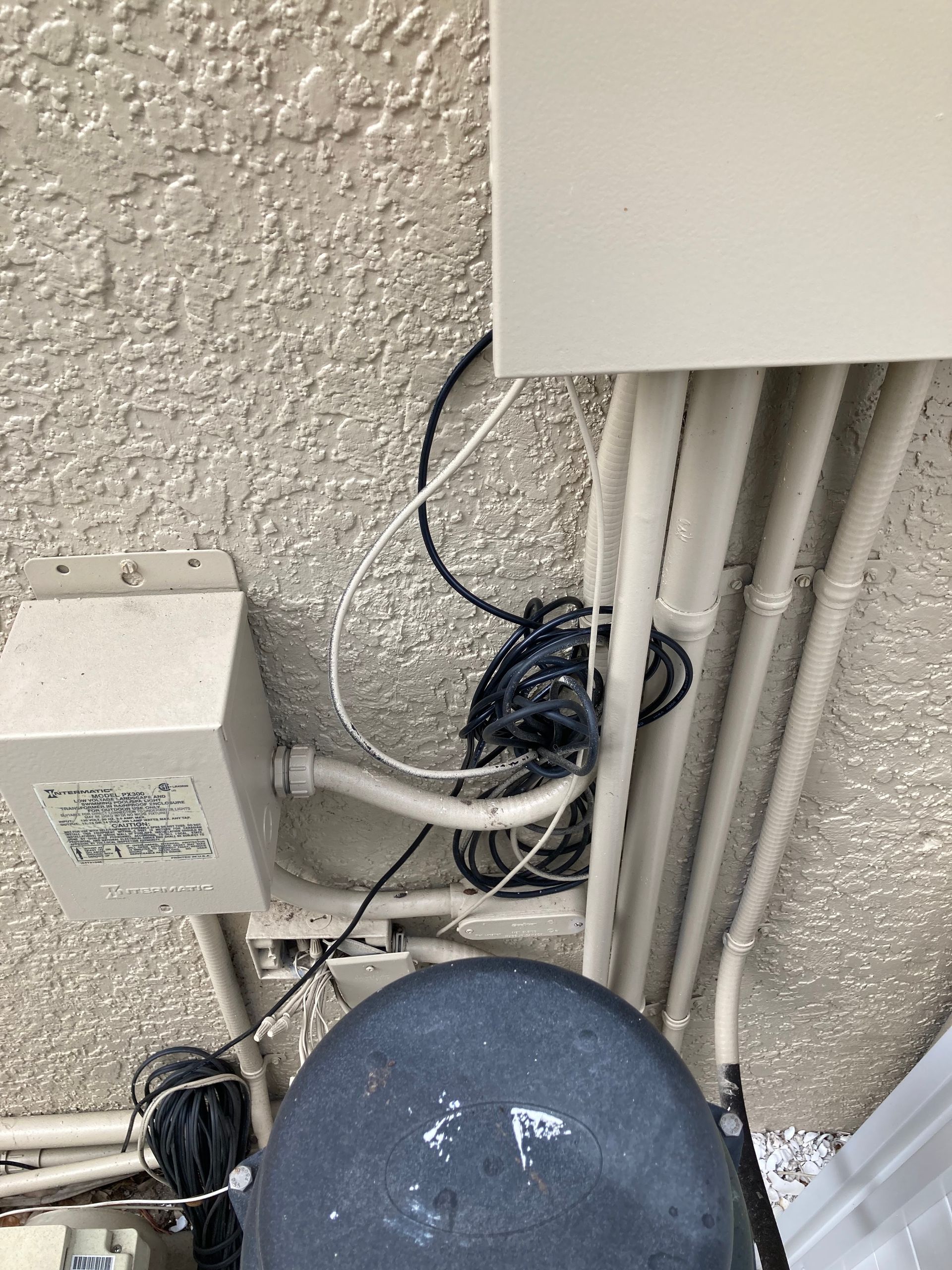 Overhead view of electrical wiring and boxes on a textured ceiling.