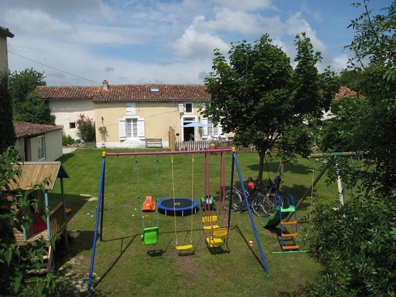 View of the enclosed garden at La Vendange with swings and slide