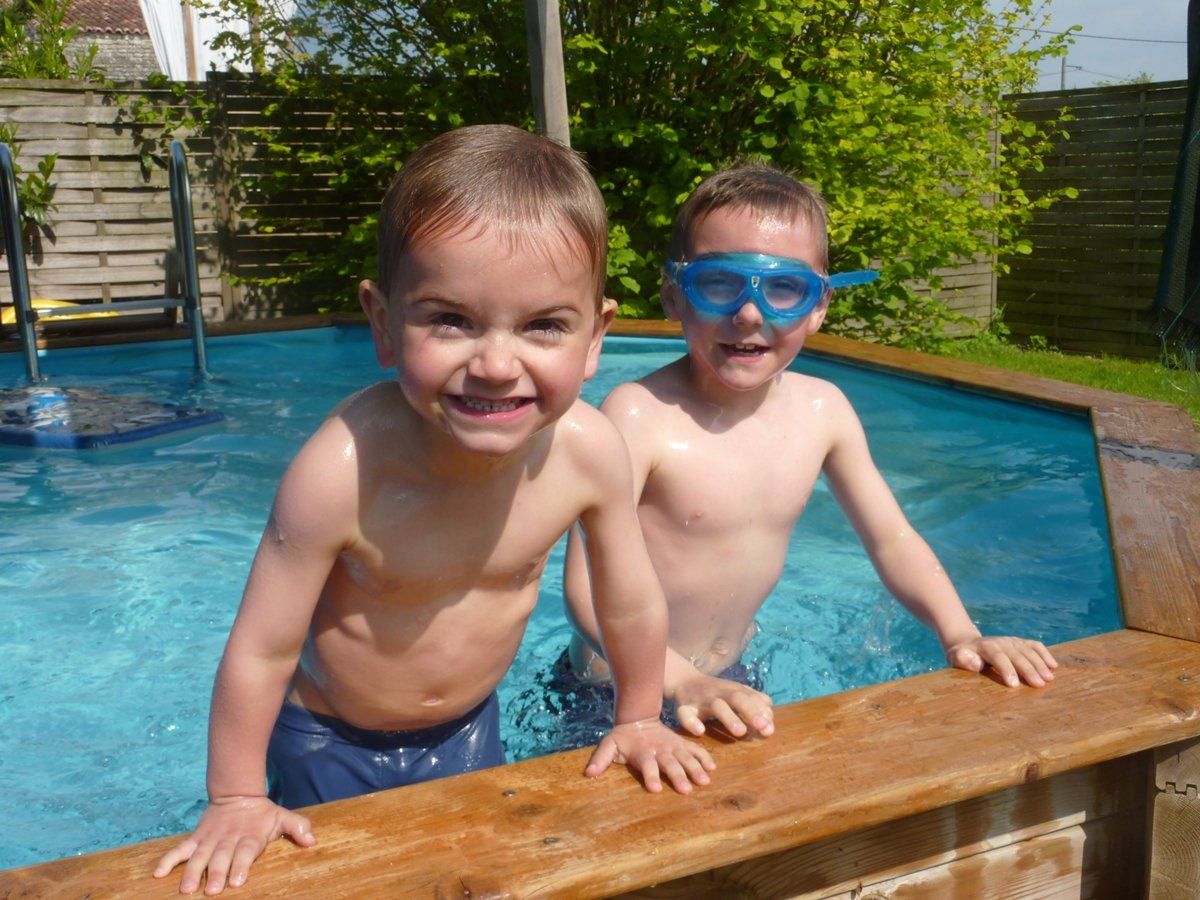 deux jeune garcons dans une petite piscine