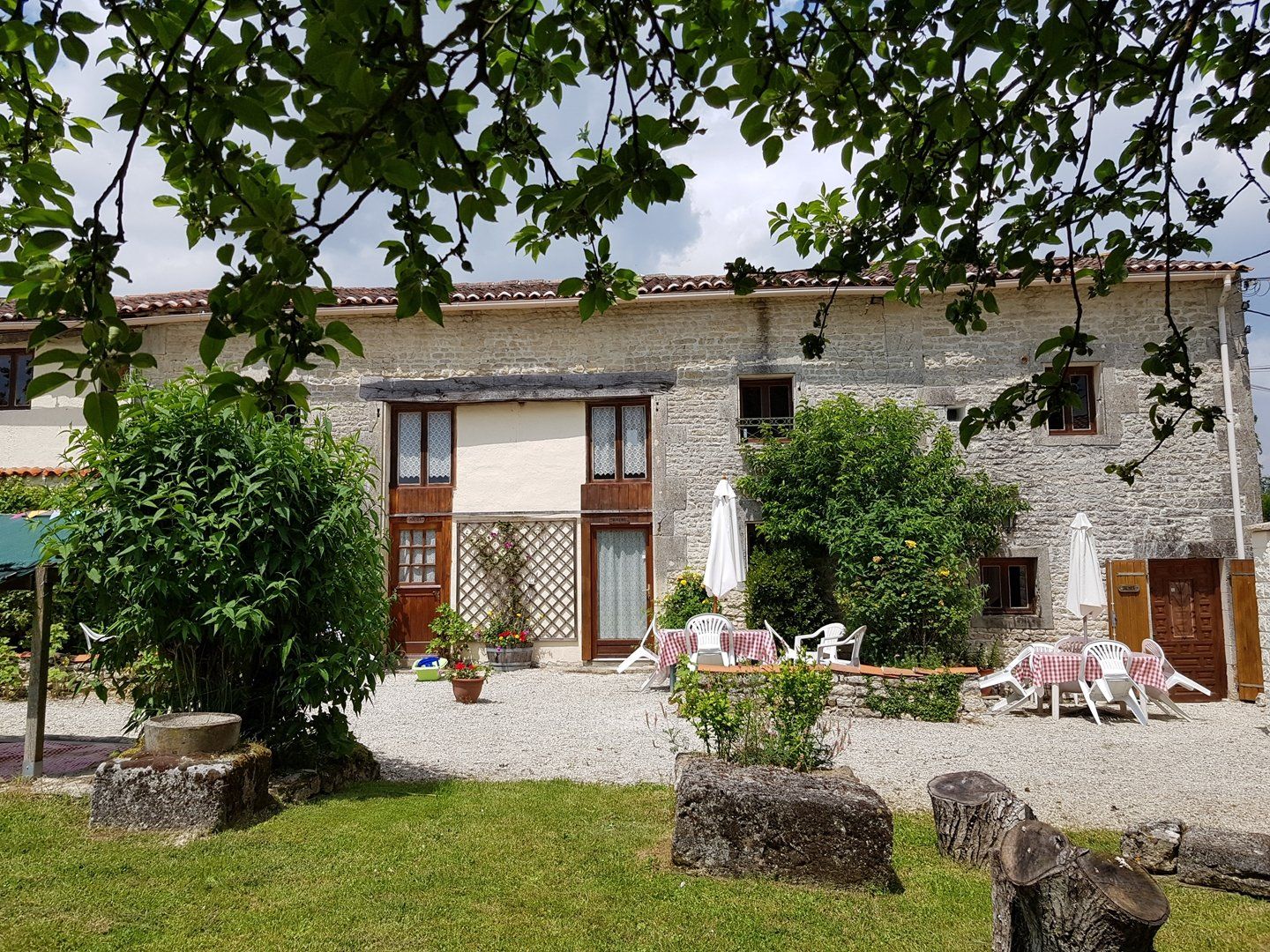 View from garden under a tree, stone holiday cottages in France