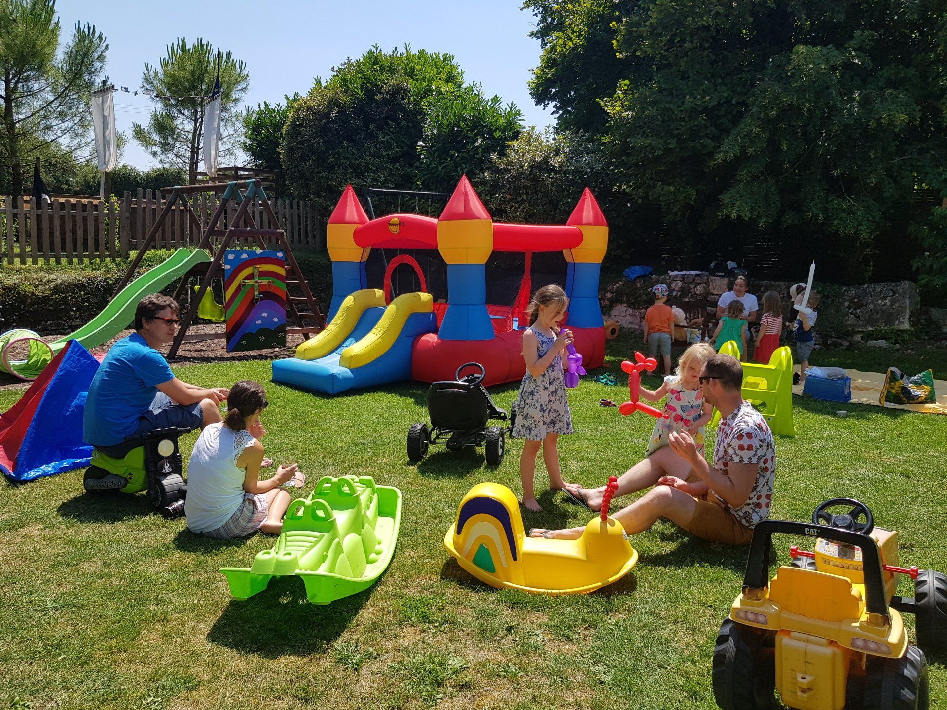 small brightly coloured bouncy castle with children playing in the garden