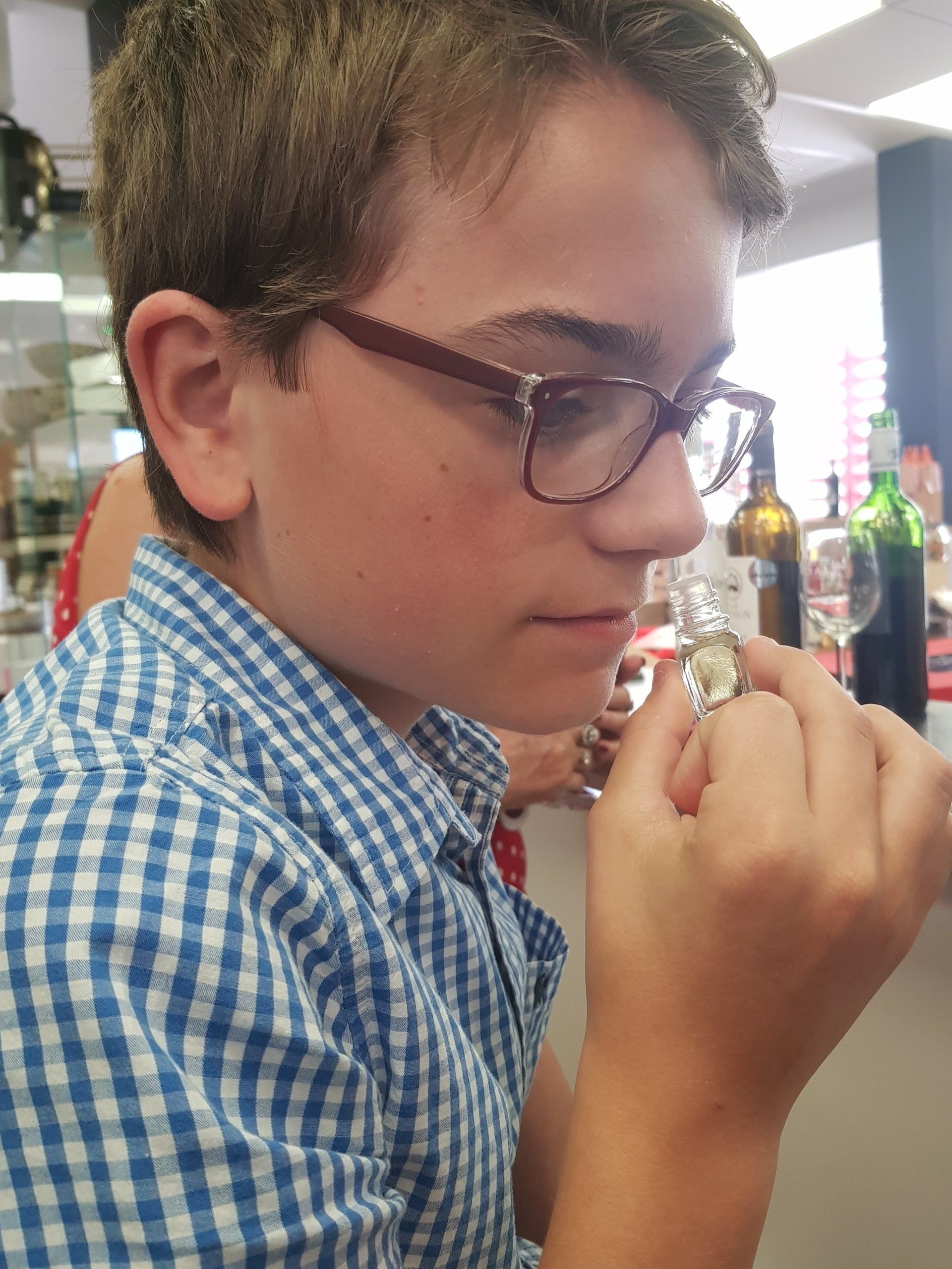 a boy sniffing a bottle containing wine scents