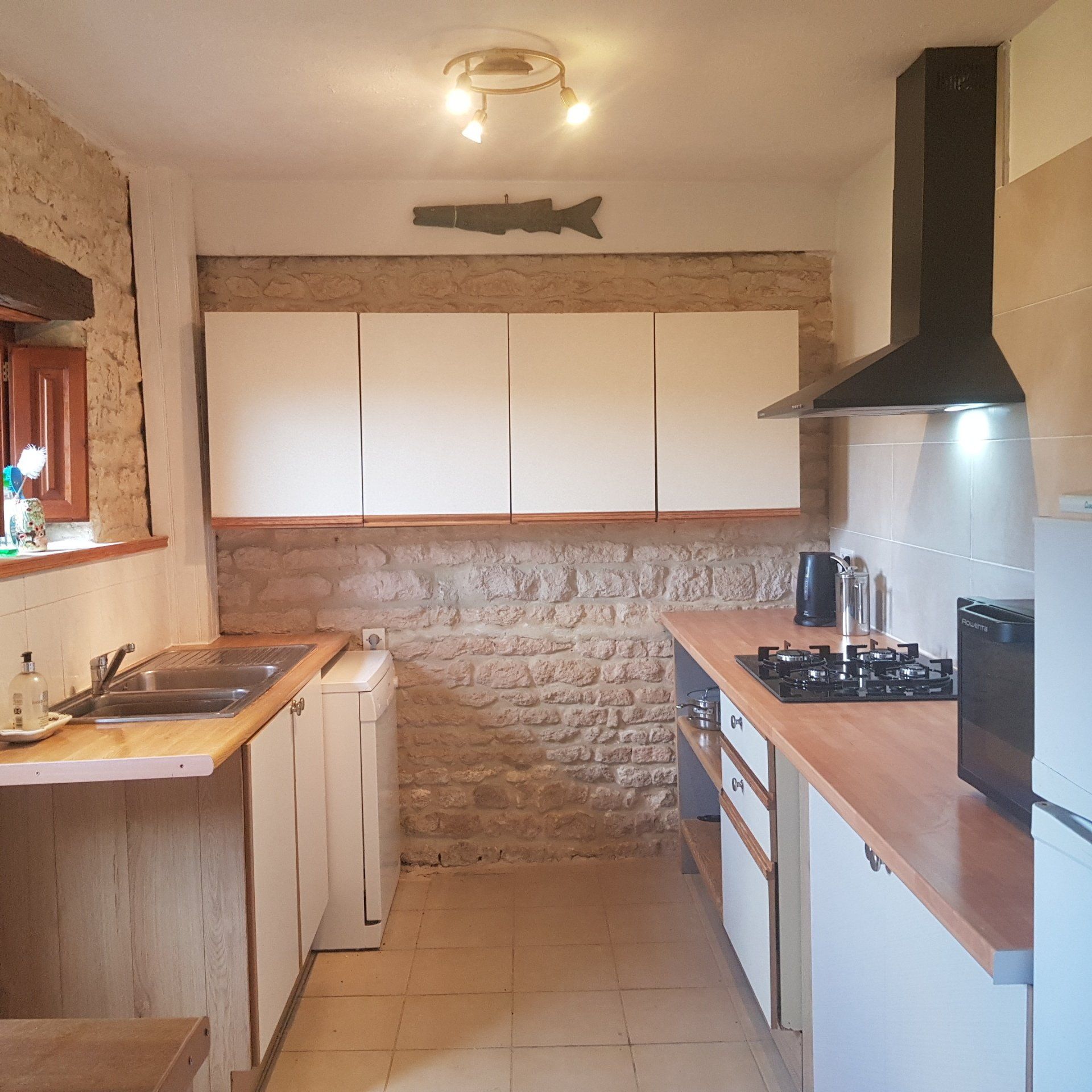 a kitchen with cream cupboard fronts and light oak worktop