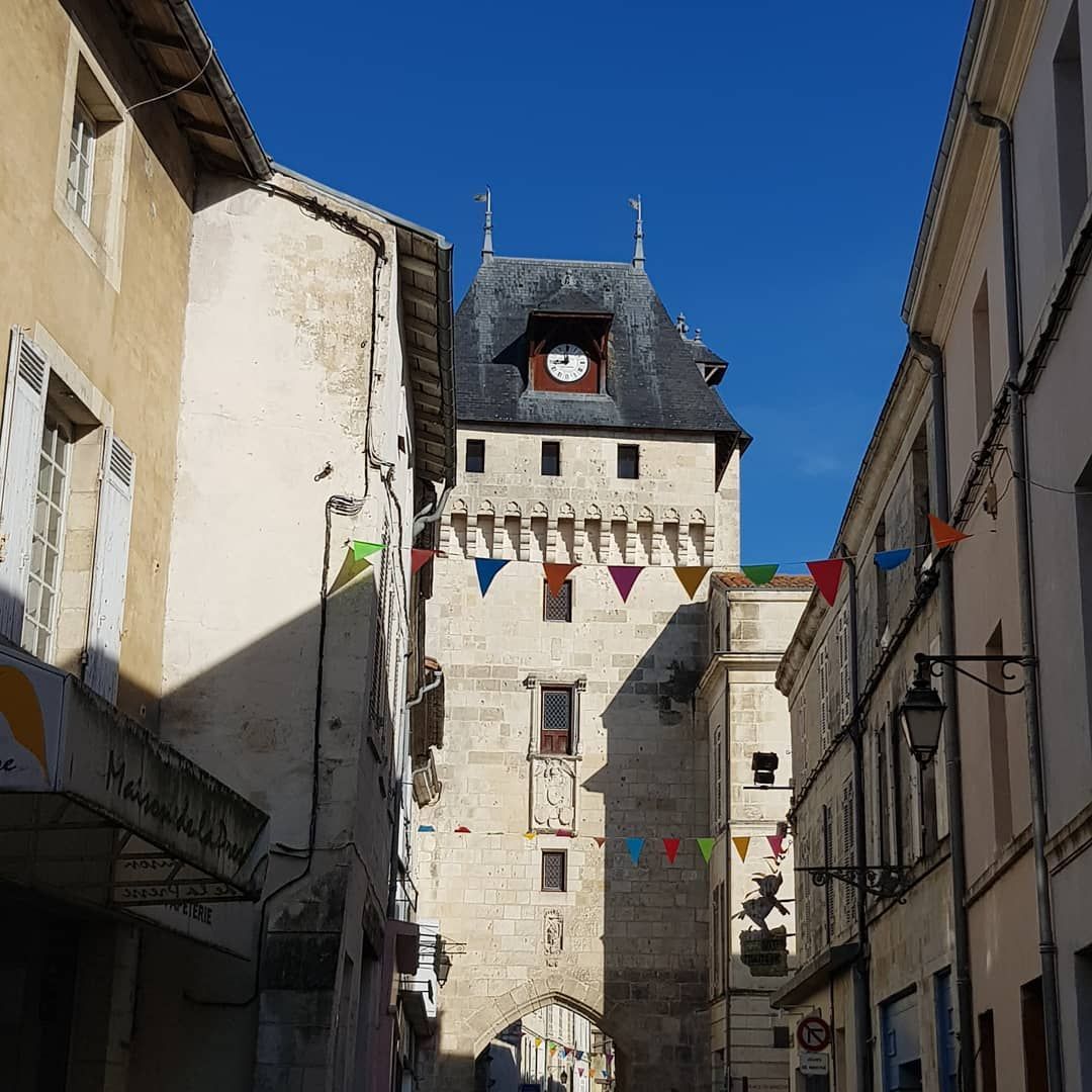 stone clock tower with slate roof in St Jean d'Angely