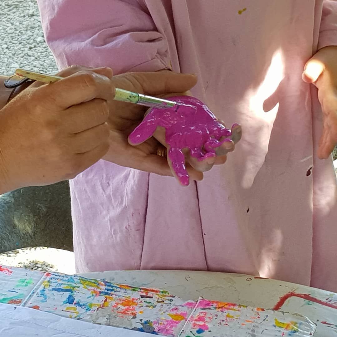 a childs hand being painted pink