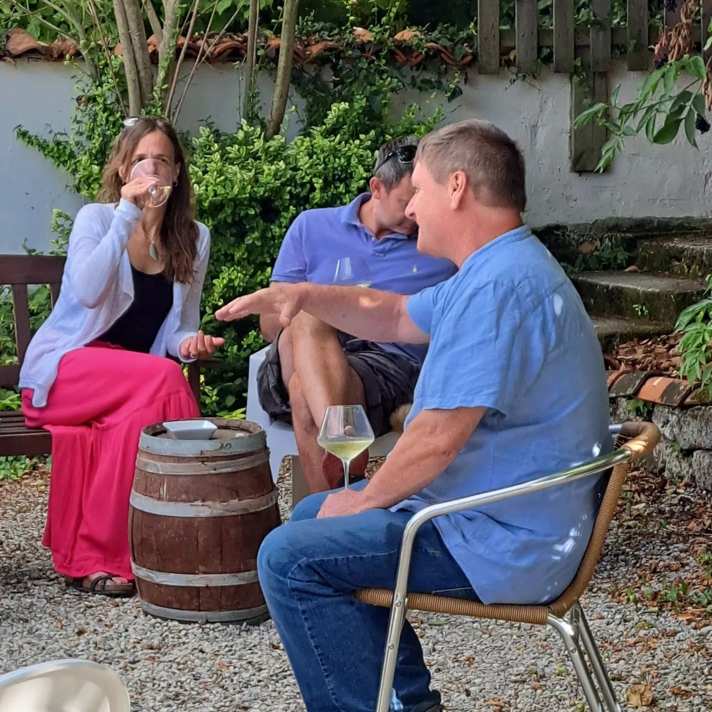 man discussing wine knowledge with a man and woman whilst drinking wine