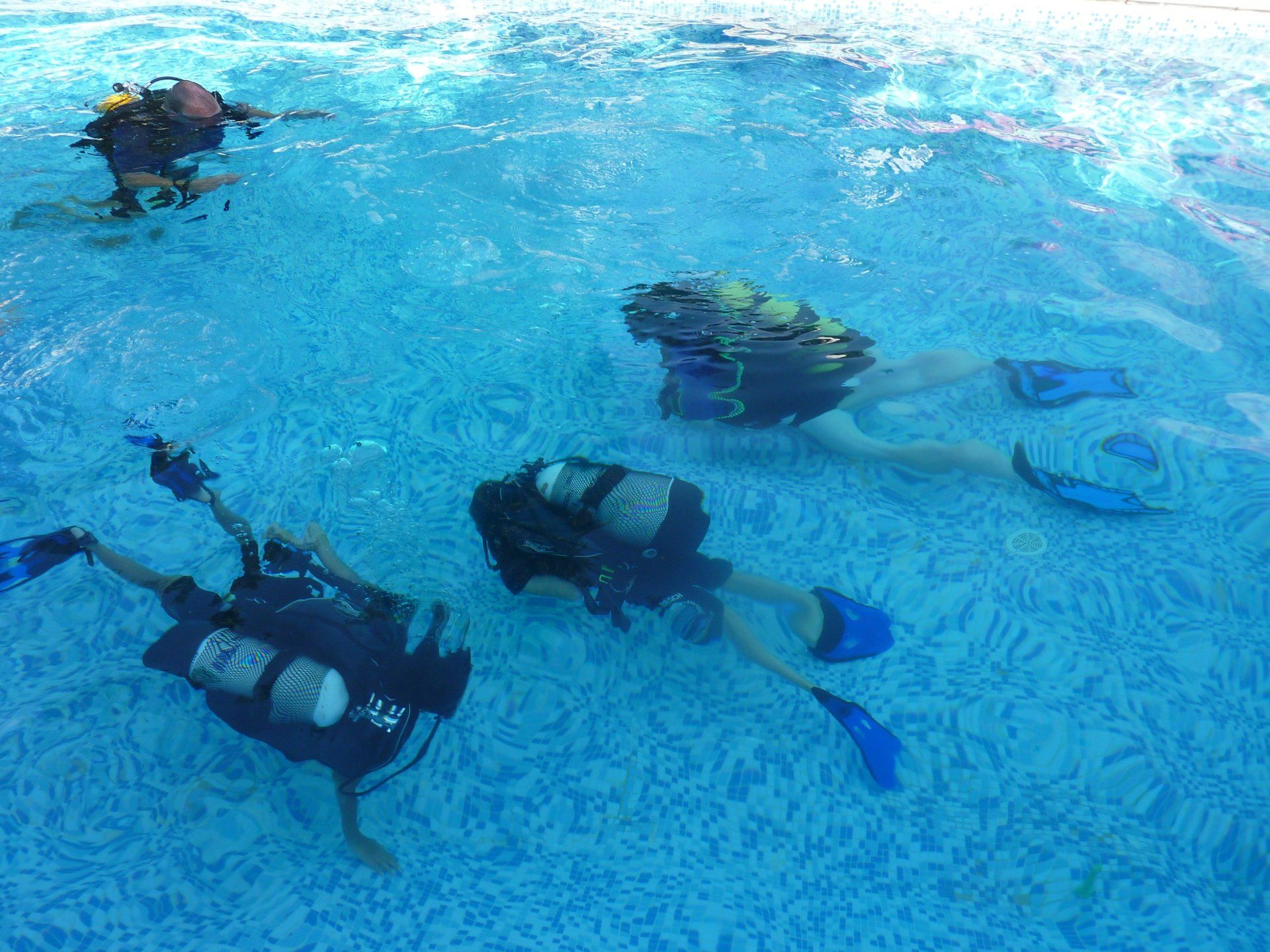 children in scuba equipment swimming under water