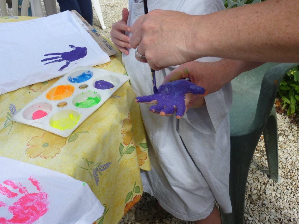 a child having their hand painted purple