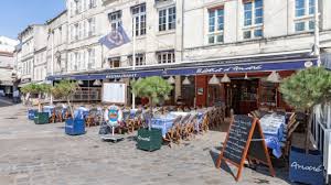 tables and chairs with blue table cloths outside the Andrés restauarnt in La Rochelle