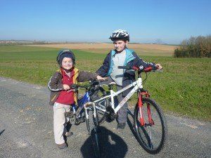 twee jonge kinderen staan naast hun fietsen