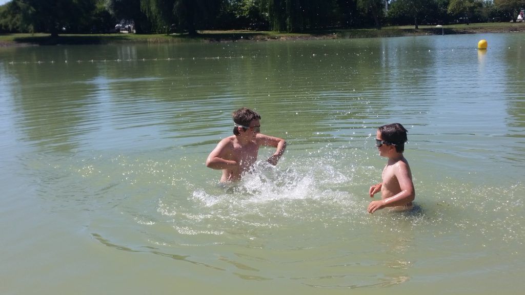two boys splashing each other in a lake