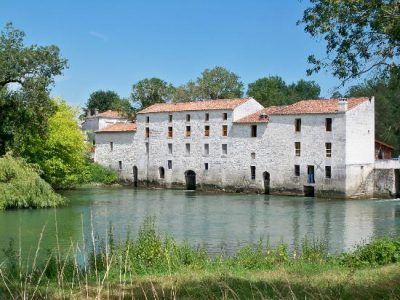 stone water mill over a river with red clay tiled roof 