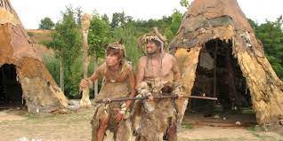 two actors dressed as cavemen at paleosite attraction in France