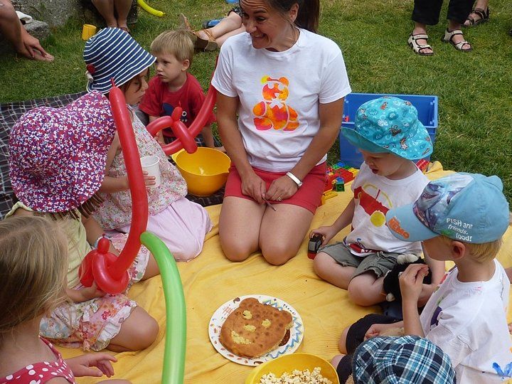 lady serving a cake at a picnic with young children