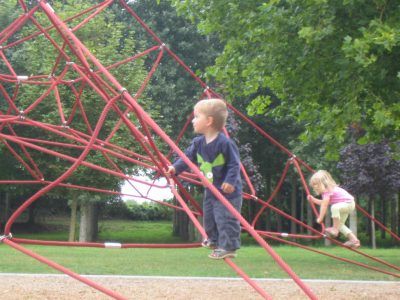 toddler climbing a rope frame