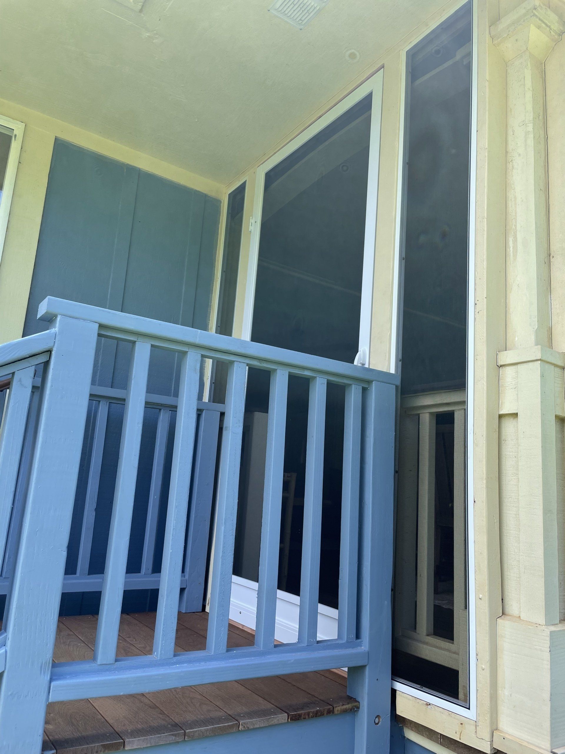 Blue porch railing with screens and painted walls.