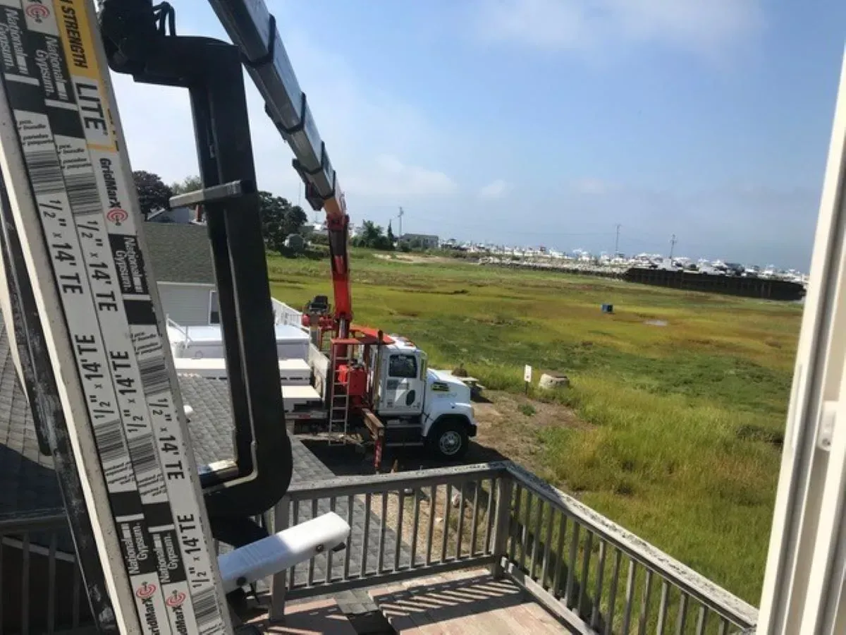 A truck with a crane attached to it is parked on a deck.