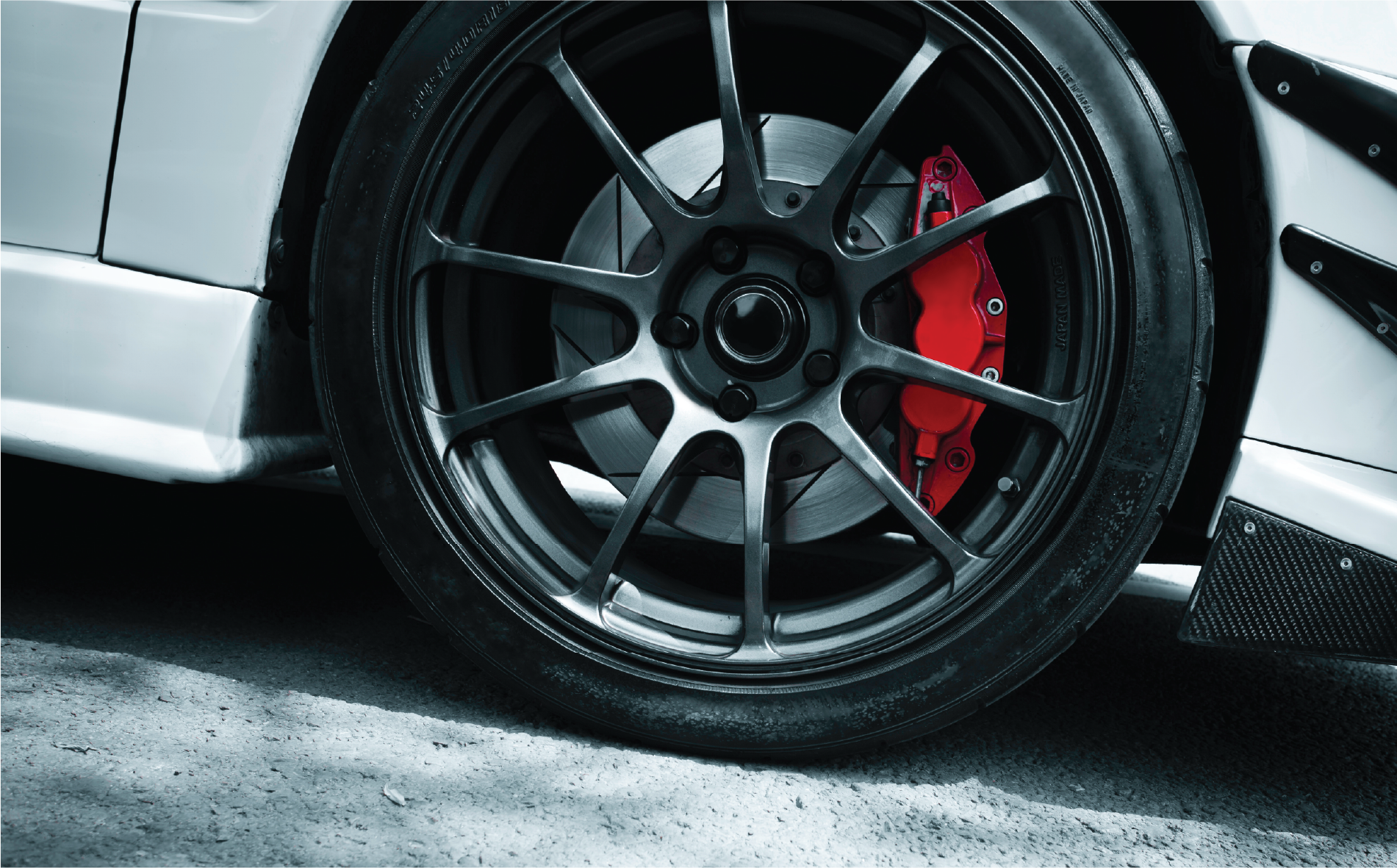 A close up of a car wheel with a red brake caliper