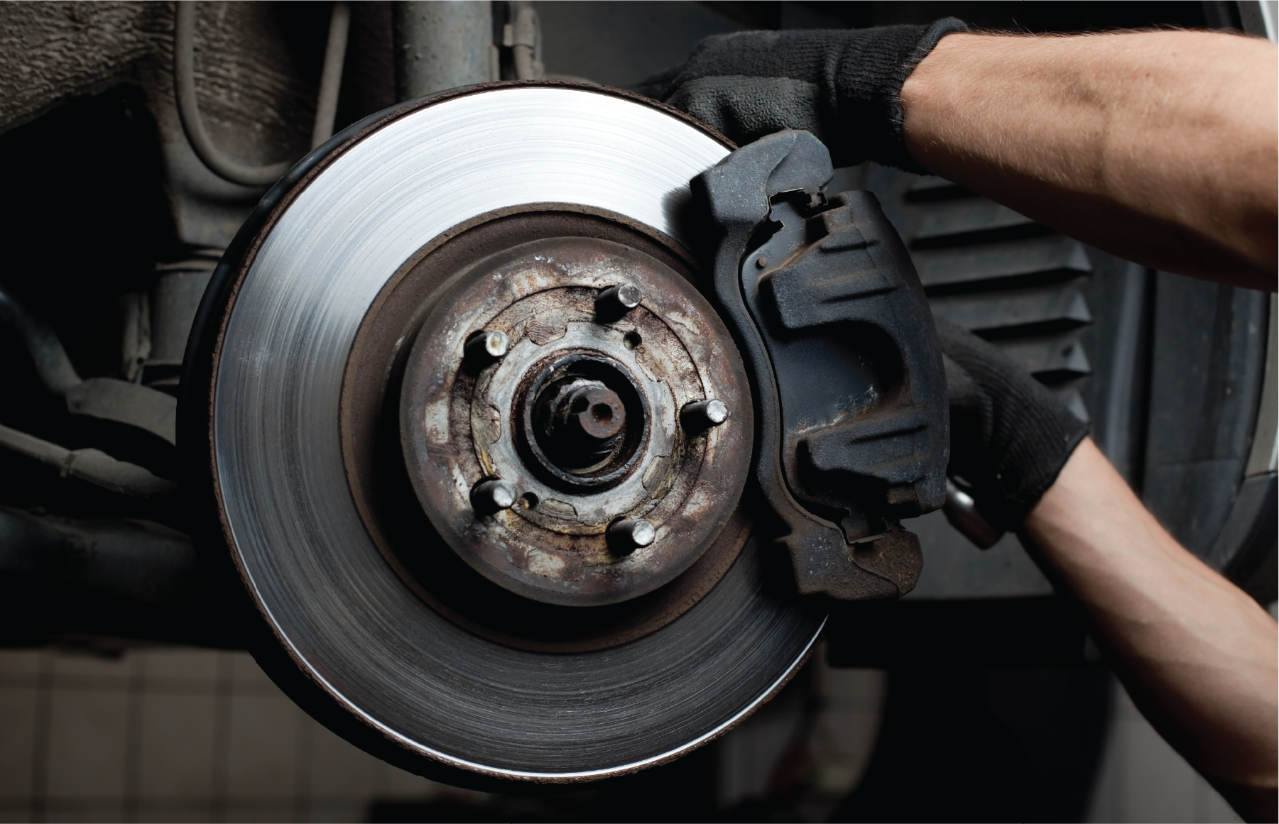 A person is fixing a brake disc on a car.