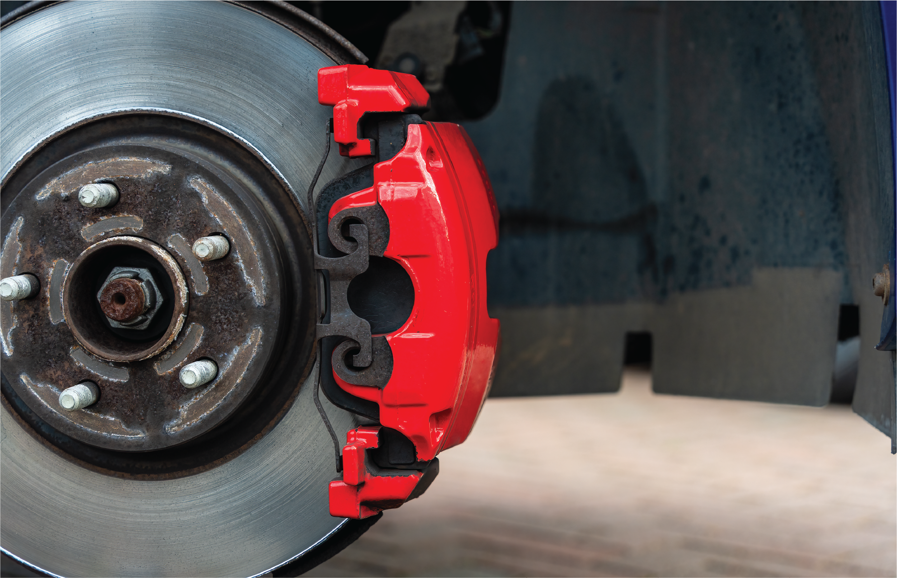 A close up of a red brake caliper on a car.