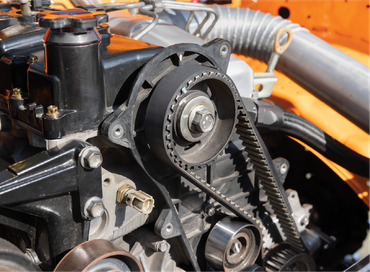 A close up of a car engine with a belt on it