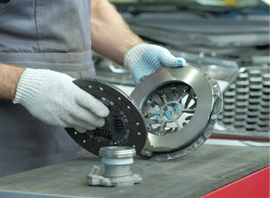 A man is holding a clutch disc in his hands.