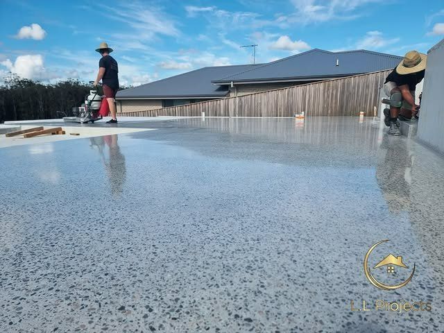 Two Men Are Working on A Concrete Floor in Front of A House — L.L Projects in Gloucester, NSW