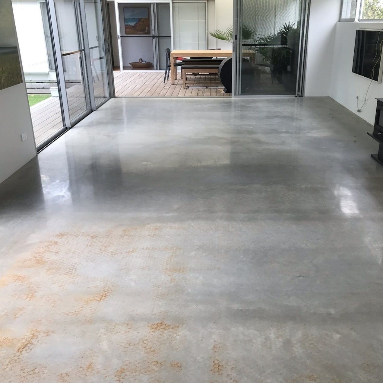 A Living Room with A Concrete Floor and A Table and Chairs — L.L Projects in Forster, NSW