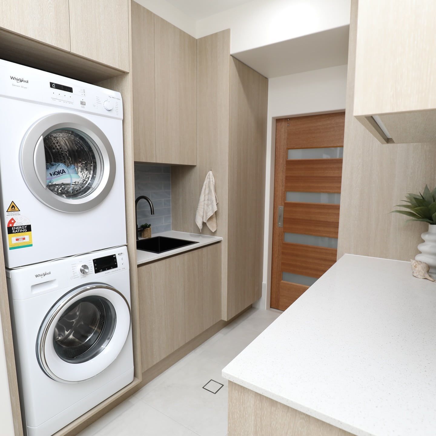 A Laundry Room with A Washer and Dryer Stacked on Top of Each Other — L.L Projects in Gloucester, NSW