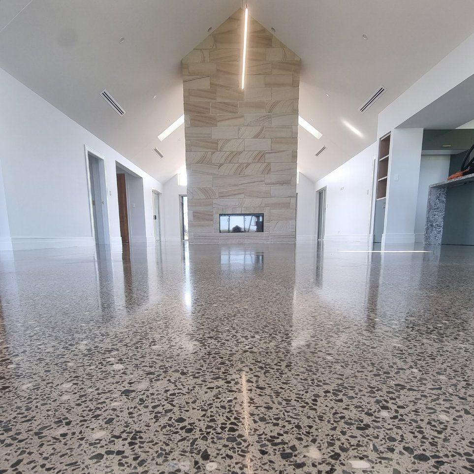 A Large Room with A Brick Fireplace and A Shiny Floor — L.L Projects in Taree, NSW