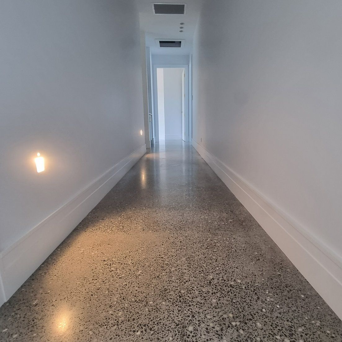 A Long Hallway with A Concrete Floor and White Walls — L.L Projects in Hallidays Point, NSW