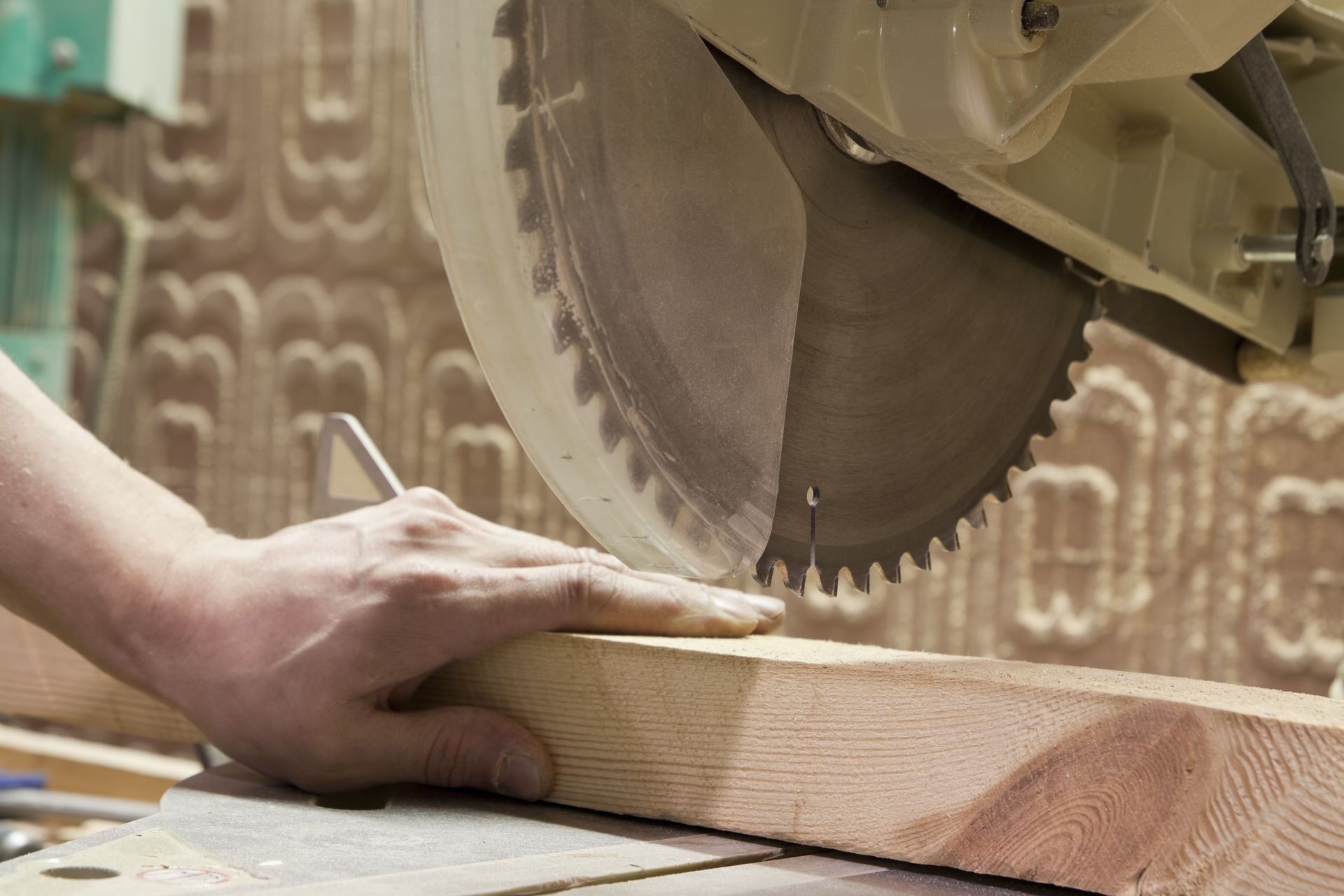 A person is cutting a piece of wood with a circular saw.